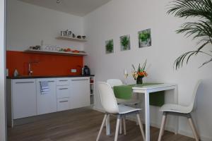 a kitchen with a white table and white chairs at Casa Stetten in Lörrach