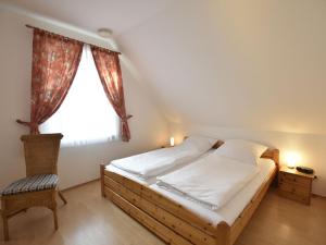 KaltenhofにあるLuxurious Holiday Home in Insel Poel Germany with Saunaの窓と椅子が備わる客室のベッド1台分です。