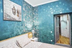 een slaapkamer met een bed en een blauwe muur bij Apartment on Lyul'ky 5 in Lviv