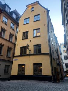 un edificio alto de color amarillo con ventanas en una calle en Hotel Sven Vintappare, en Estocolmo