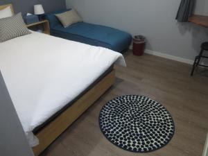 1 dormitorio con cama y alfombra en el suelo en HAH Guesthouse en Seúl