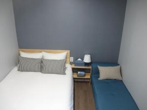 首爾的住宿－哈哈旅館，一间卧室配有一张床和一张蓝色的沙发