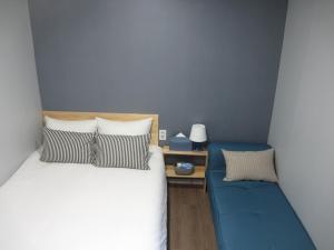 una camera con un letto e un divano blu di HAH Guesthouse a Seul