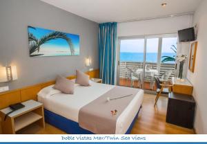 a hotel room with a bed and a view of the ocean at Hotel Neptuno in San Pedro del Pinatar