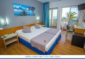 サン・ペドロ・デル・ピナタルにあるHotel Neptunoの大きなベッドとバルコニーが備わるホテルルームです。