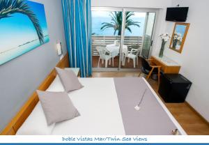 a hotel room with a bed with a view of the ocean at Hotel Neptuno in San Pedro del Pinatar