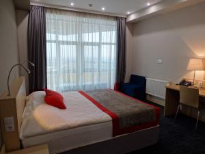 a hotel room with a bed and a window at Ramada Hotel & Suites by Wyndham Alabuga in Yelabuga