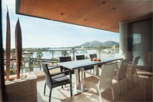 a dining room with a table and chairs on a balcony at Luxury sea view Apartment in Puerto de Alcudia in Alcudia