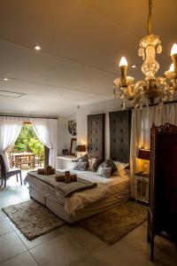 a bedroom with a large bed and a chandelier at A Whale of a View Bed & Breakfast in Plettenberg Bay