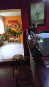 eine Küche mit einer Theke mit einer Mikrowelle und 2 Hockern in der Unterkunft Hostal El Venero in Sotillo de la Adrada