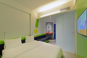 a bedroom with a white bed and a green wall at POP! Hotel Solo in Solo
