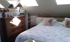 a bedroom with a bed with a wooden dresser and a dresser at Garden View Apartment in Salcombe