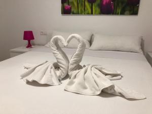 dos cisnes de toalla están sentados en una cama en Apartamento Centro Historico Teruel, en Teruel