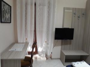 sala de estar con escritorio, TV y mesa en chicchinella, en Altamura