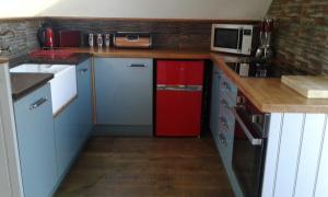 ソルカムにあるGarden View Apartmentのキッチン(赤い冷蔵庫、電子レンジ付)