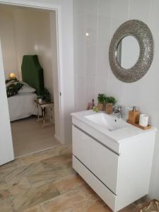 a bathroom with a white sink and a mirror at Casa do Penedo in Vila Franca do Campo