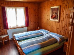 RosswaldにあるChalet Bärgsunnaの木製の部屋にベッド2台が備わるベッドルーム1室