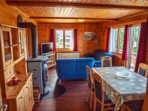 a living room with a table and a stove at Chalet Bärgsunna in Rosswald