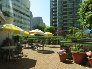 a patio with tables and chairs and umbrellas at Rosedale on Robson Suite Hotel in Vancouver