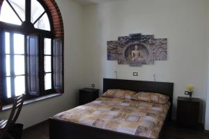 een slaapkamer met een bed en een groot raam bij Passaggio a Nord Ovest in Settimo Vittone
