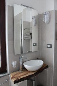 een badkamer met een witte wastafel en een spiegel bij Passaggio a Nord Ovest in Settimo Vittone