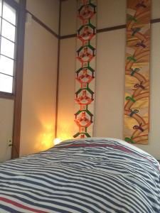 a bedroom with a bed with a colorful head board at Kanazawa-Hachitabi Sennichi in Kanazawa