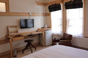 Dormitorio con cama, escritorio y TV en Melekli Konak en Amasya