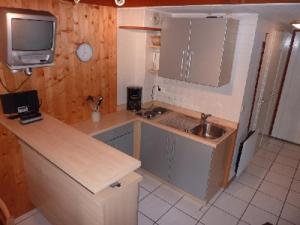 a kitchen with a sink and a tv on the wall at Mont Blanc Soleil E17 in Manigod