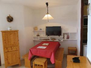 a living room with a table with a red table cloth at LE Hameau 001 in Manigod