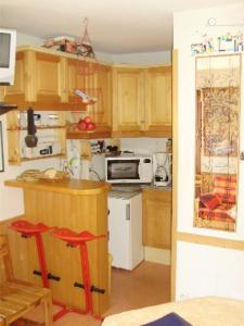 a kitchen with wooden cabinets and a stove top oven at MONT BLANC Soleil C19 in Manigod