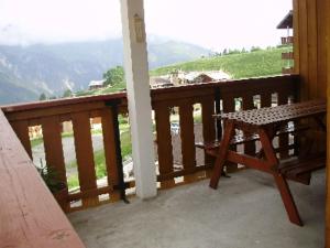 a wooden porch with a bench on a balcony at MONT BLANC Soleil C19 in Manigod