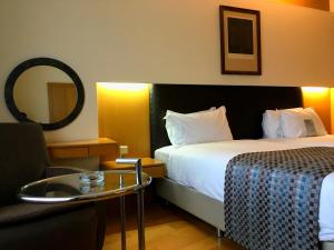 a hotel room with two beds and a chair at Surmeli Istanbul Hotel in Istanbul