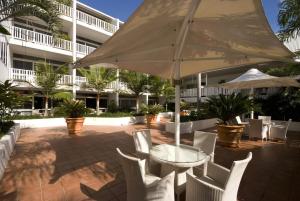 a patio with a table and chairs and an umbrella at Ramada By Wyndham Cairns City Centre in Cairns