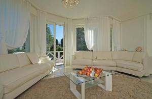 a living room with couches and a table with fruit on it at Villa Sabine: New Modern villa with Private pool in Toscolano Maderno