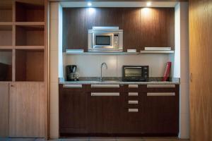 a kitchen with a sink and a microwave at Apartamentos Turisticos Atlantida in Funchal