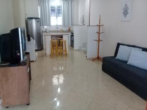 阿拉亚尔-杜卡布Acomodações Araujo的客厅里有一张沙发和一个厨房