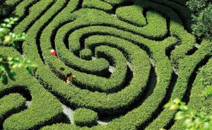 a woman walking through a maze in a garden at Shangri-La Kuala Lumpur in Kuala Lumpur