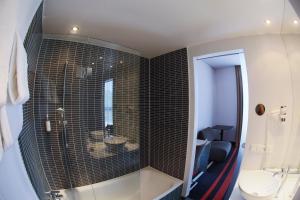a bathroom with a shower, toilet and sink at enso Hotel in Ingolstadt
