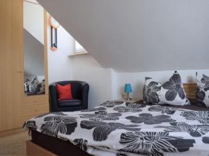 ein Schlafzimmer mit einem Bett und einem schwarzen Stuhl in der Unterkunft Haus Bodanblick in Bodman-Ludwigshafen