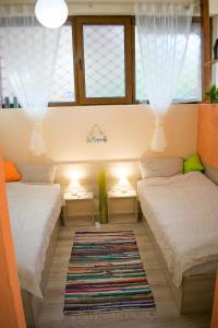 two beds in a room with windows and a rug at 4 Seasons apartments, A1 in Plovdiv