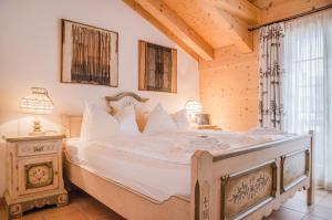 ein Schlafzimmer mit einem großen weißen Bett in einem Zimmer in der Unterkunft Apartment Stotzhalten DG - GRIWA RENT AG in Grindelwald