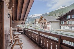 a balcony with chairs and a view of a mountain at Apartment Stotzhalten DG - GRIWA RENT AG in Grindelwald