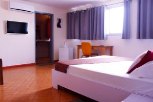 Habitación de hotel con 2 camas y TV en Maison d'hôtes Opanoramic, en Dakar