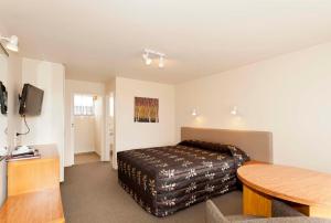 une chambre d'hôtel avec un lit et une table dans l'établissement Colonial Inn Motel, à Christchurch