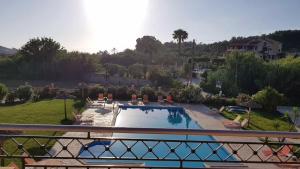 balkon z widokiem na basen w obiekcie Mythos apts rentit w mieście Agios Stefanos
