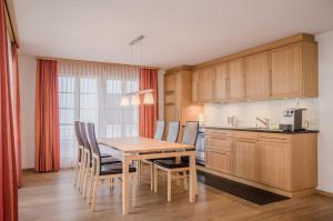 a kitchen with a dining room table and chairs at Apartment Stotzhalten 3.5 - GriwaRent AG in Grindelwald