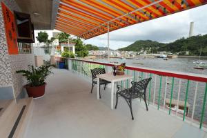 a table and chairs on a balcony with a view of the water at Man Lai Wah Resort in Hong Kong