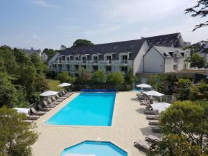 una vista aérea de un hotel con piscina y sillas en Résidence Goélia Le Domaine des Glénan en Fouesnant