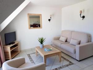 uma sala de estar com um sofá e uma mesa em Résidence Goélia Le Domaine des Glénan em Fouesnant