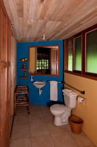 Baño azul con aseo y lavamanos en Huasquila Amazon Lodge, en Cotundo